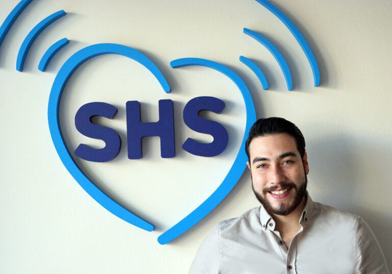 Geschäftsführer Emre Turgul vor dem SHS Logo