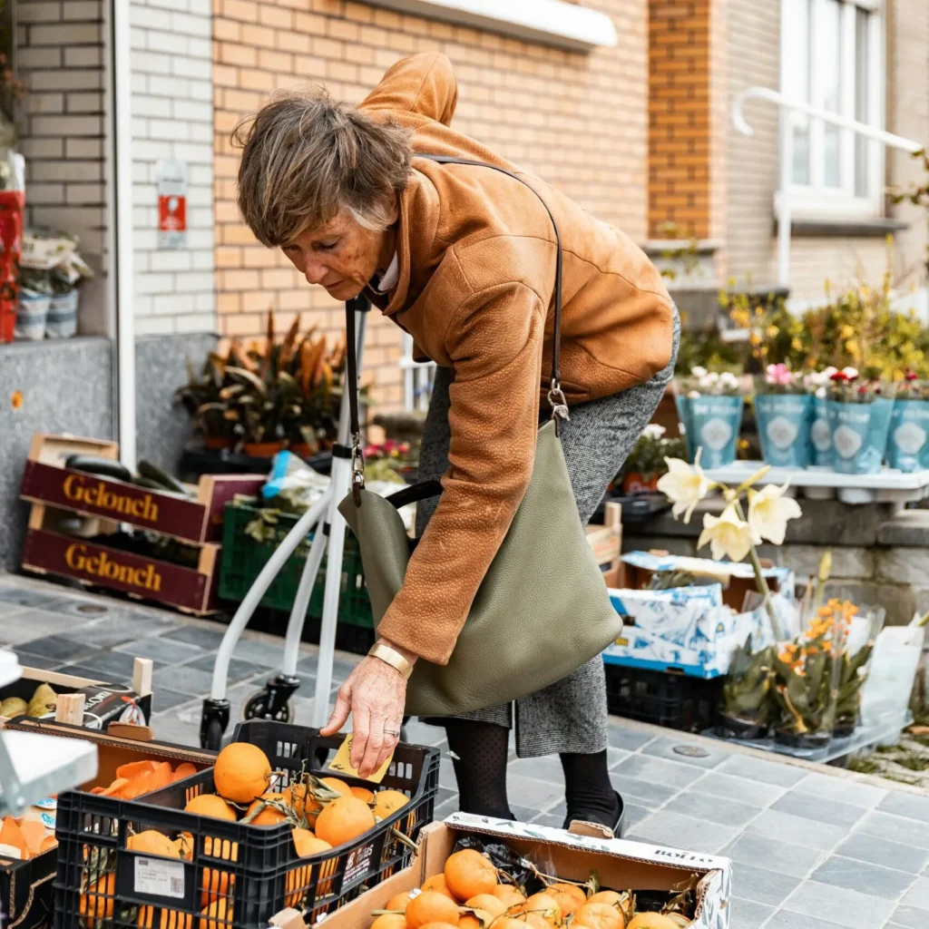 Seniorin geht mit mobilem Hausnotruf sicher einkaufen